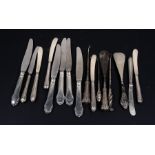 A group of silver handled knives and other silver handled items.