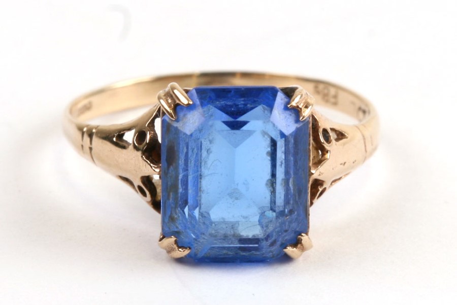 A 9ct gold dress ring set with a square blue stone, approx UK size 'L'.