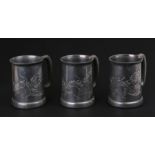 A group of three Chinese Kwang Heng Swatow pewter tankards decorated with dragons.