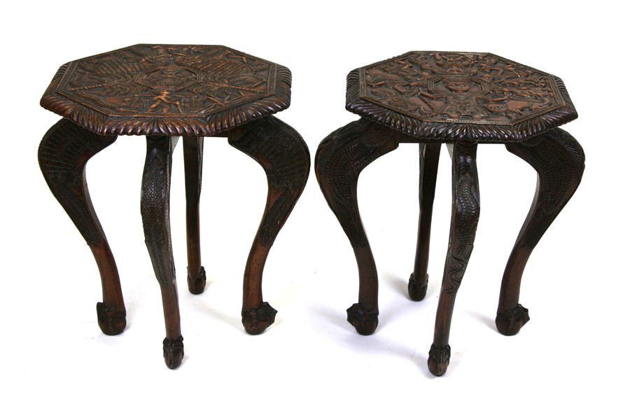 A pair of African Yoruba carved wooden side tables decorated with elephants, figures and palm trees,