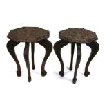 A pair of African Yoruba carved wooden side tables decorated with elephants, figures and palm trees,