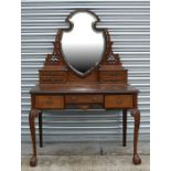 A George III style mahogany dressing table, the superstructure having a shield shaped central mirror