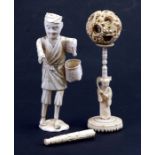 A Japanese okimono depicting a man with a basket, 18cms (7ins) high; together with a puzzle ball;