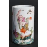 A Chinese famille rose brush pot decorated a figure standing on a mythical sea beast with