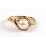 A 9ct gold ring set with a single pearl flanked by a pair of diamonds, approx UK size 'N'.