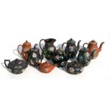 A large quantity of Wedgwood Antico Rosso teapots decorated with enamelled Chinese flowers.Condition