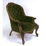 A Victorian carved walnut armchair with upholstered seat and button back.