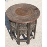 An Indian hardwood circular table with brass inlay on folding pierced base, 53cms (21ins) diameter.