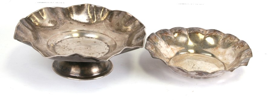 A white metal bowl on stand; together with a similar silver plated bowl, the largest 25cms (9.75ins)