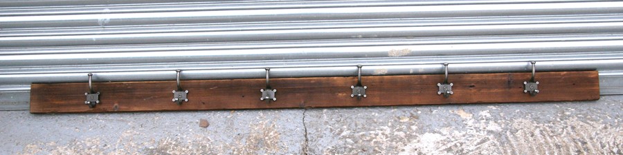 A set of six coat hooks on a pine backboard, 79cms (31ins) wide.