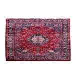 A Persian Mashad woollen hand knotted carpet with central floral medallion within floral borders
