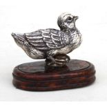 A carved ivory figure of a bird mounted on a wooden plinth, 5cms (2ins) high.
