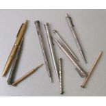 A group of propelling pencils and pens to include silver examples.