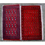 A pair of Persian Baluch woollen handmade rugs with geometric design on a red ground, each approx