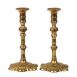 A pair of brass petal based candlesticks, 21cms (8.25ins) high.