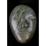 An Inuit mottled green stone carving in the form of a face, 16cms (6.25ins) high.Condition