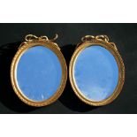 A pair of George III style oval gilt gesso ribbon tie wall mirrors, 23cms (9ins) diameter.