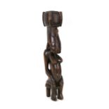 An African tribal figure in the form of a woman seated on a stool, 45cms (17.5ins) high.