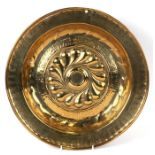 A 16th / 17th century Nuremburg brass alms dish with central ornate boss within a band of Gothic