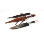 Two African tribal daggers in leather sheaths. Blade lengths of 18.5cms (7.25ins) and 18cms (7ins)