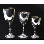 Two Victorian silver goblets; together with a similar smaller, the largest 23cms (9ins) high, weight