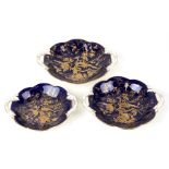 A set of three Coalport graduated two handled dishes decorated with gilded birds and foliage on a