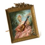 A late 19th century portrait miniature depicting a lady playing a lute, mounted in an ornate metal