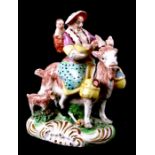 A Staffordshire pottery group, in the form of a woman with children riding a goat