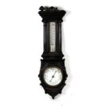 An Edwardian ebonised wheel barometer with thermometer, in a carved cased, 102cms (40ins) high.