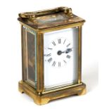 A carriage clock with white porcelain dial with Roman numerals, in a four pillar brass case, 7.75cms
