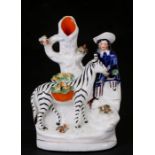 A 19th century Staffordshire spill vase depicting a figure with a zebra, 16cms (6.25ins) high.