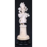 A 19th century Dieppe ivory figure in the form of a young lady holding a parasol, overall 23cms (