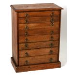 A pine collector's cabinet with eight graduated drawers, on a plinth base, 48cms (19ins) wide.