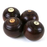 A set of four lignum vitae lawn bowls.