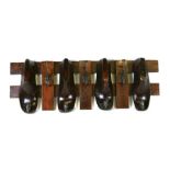 A set of seven coat hooks mounted on a wooden frame with four shoe lasts, 77cms (13.5ins) wide.