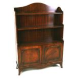 A mahogany waterfall bookcase with cupboards. 84cm (33 ins) wide