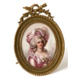 A portrait miniature depicting a lady wearing a pink dress and feathered headdress, signed '