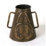 An Arts & Crafts twin handled metalware vessel with repousse decoration and inscription relating