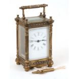 An ornate Edwardian brass cased carriage clock, the white enamel dial with Roman numerals. 13cm (5