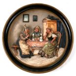 A 19th century German painted terracotta wall plaque depicting old women having tea, impressed '