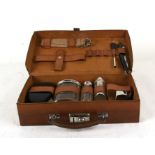 A gentleman's leather travelling vanity case with fitted interior, with white metal presentation