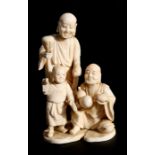 A 19th century Japanese ivory figural group depicting two men and a young boy, 15cms (6ins) high.