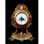 An early 20th century gilt metal Continental mantel clock in the Rococo style, the enamel dial