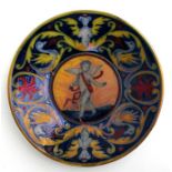 A maiolica dish decorated with a central winged cherub, 23cms (9ins) diameter (a/f).Condition