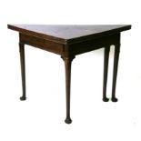 A George III mahogany folding tea table of triangular form on tapering legs and pad feet, 107cms (