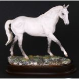 A limited edition Royal Doulton model of a horse - Desert Orchid - numbered 2932/7500, on a wooden