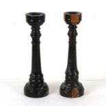 A pair of turned lignum vitae candlesticks, 23cms (9ins) high.