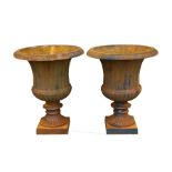 A pair of cast iron urns in the classical form, each 37.5cms (14.5ins) diameter (2).