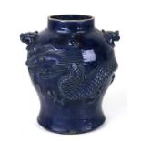 A Chinese blue glazed pottery vase decorated in relief with a scrolling dragon and with lion mask