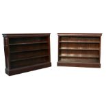 A pair of figured walnut open bookcases with three adjustable shelves, on plinth bases, 160cms (